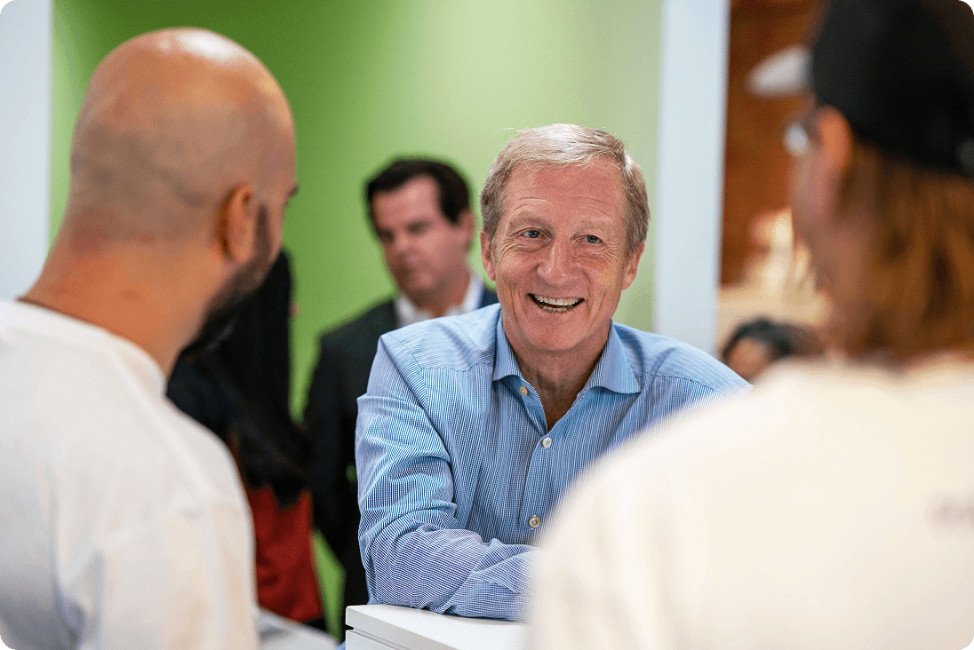 Tom Steyer smiling at a roundtable meeting